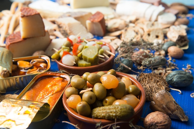 table set with an aperitif consisting of different foods cheeses and cans of pickles