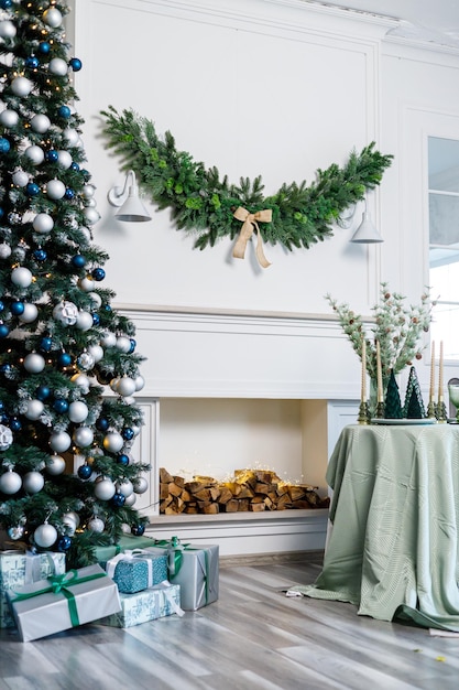 Table setting for Christmas or New Year's dinner with candles decorations tablecloth and napkins on the background of a Christmas tree in an apartment