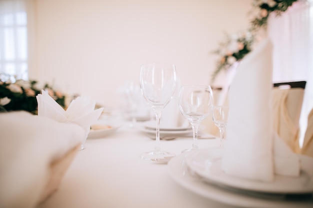 Table setting in a restaurant with glasses plates and napkins