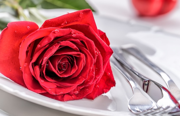 Table setting for valentines or wedding day with red roses Romantic table setting for two