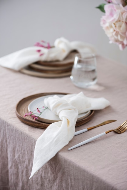 Table setting with Handmade ceramic plates on linen tablecloth and flowers. Party concept