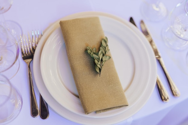 A table setting with a napkin and a leaf on it