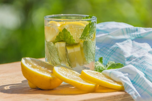 On a table sparkling water with lemon and mint.