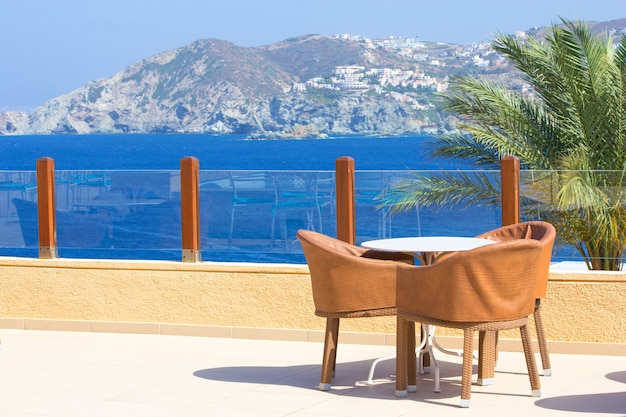 Table and three chairs on terrace with beautiful sea view