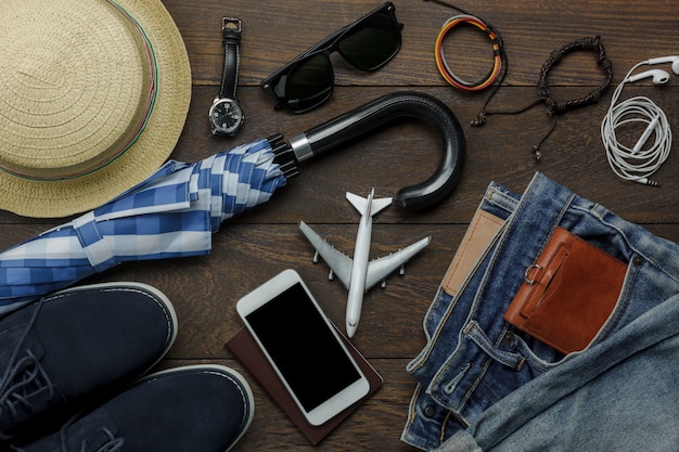 Table top view of accessories fashion men for travel with technology concept.Essential item for the teenage or adult gentlemen and travel for trip holidays.Mix of object on the modern rustic wooden.