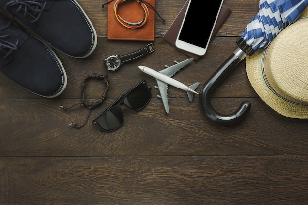 Table top view of accessories fashion men for travel with technology concept.Essential item for the teenage or adult gentlemen and travel for trip holidays.Mix of object on the modern rustic wooden.