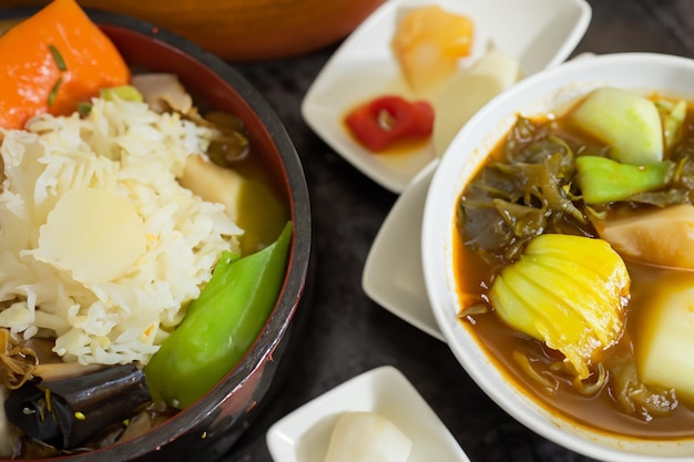 a table with bowls of food including rice rice and rice