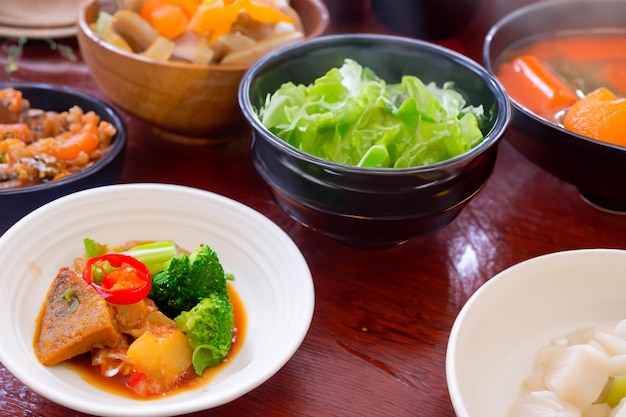 a table with bowls of food including salad salad and a bowl of salad