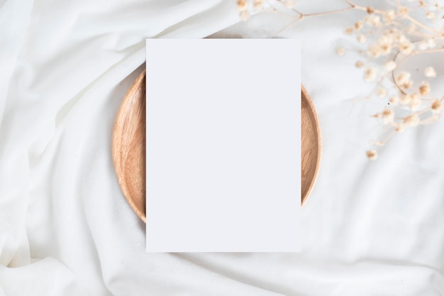 A table with cotton flowers and wood plate or tray and blank card