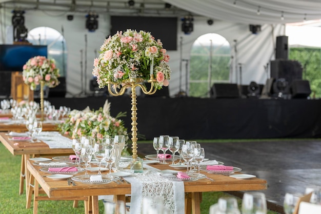 Table with flower arrangement and crockery at a social event in Event Garden