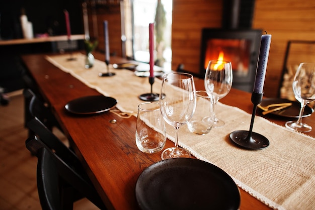 Table with paltes and candies in modern wooden house with fireplace