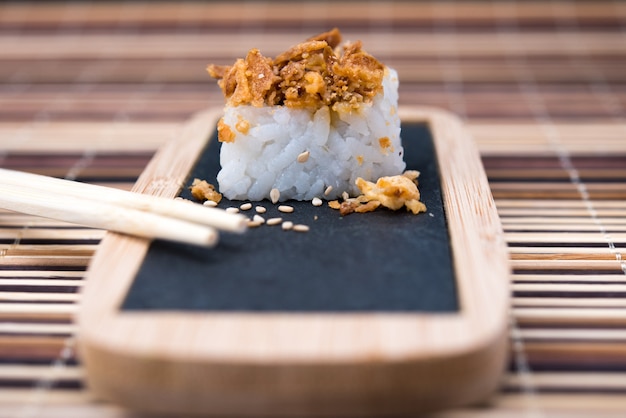 Table with sushi and chopsticks on bamboo