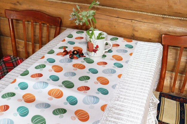 Table with tablecloth wooden retro chairs in rustic house