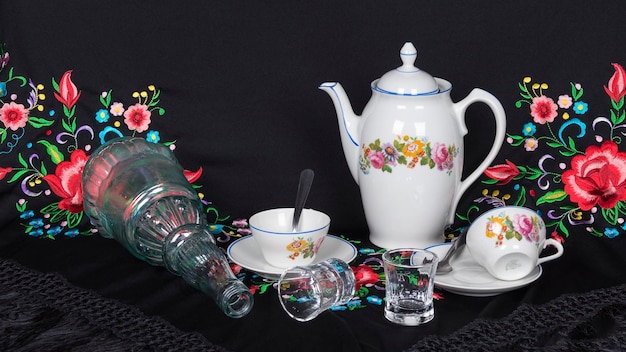 Photo a table with a teapot, a glass and a cup on it