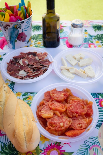 Table with typical starters of the Mediterranean diet, cheese, Iberian ham, tomato and olive oil