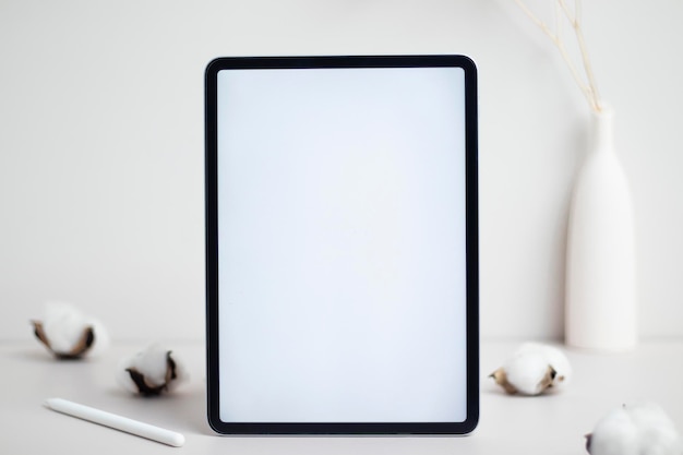 Tablet empty white screen with pencil and cotton flower on white background mockup for design