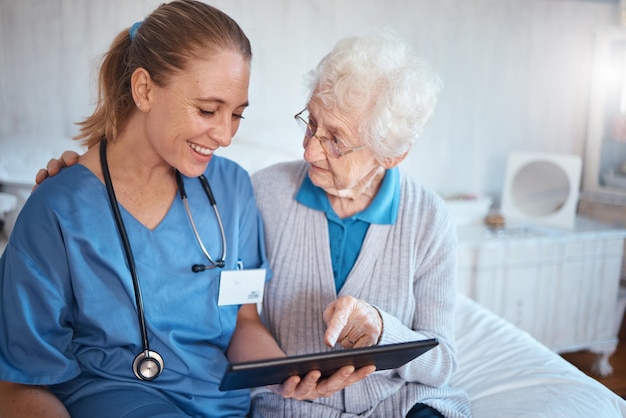 Tablet nurse or doctor consulting an old woman in a nursing home bedroom with blood pressure and heart test results Smile trust and happy healthcare worker with a senior persons medical report