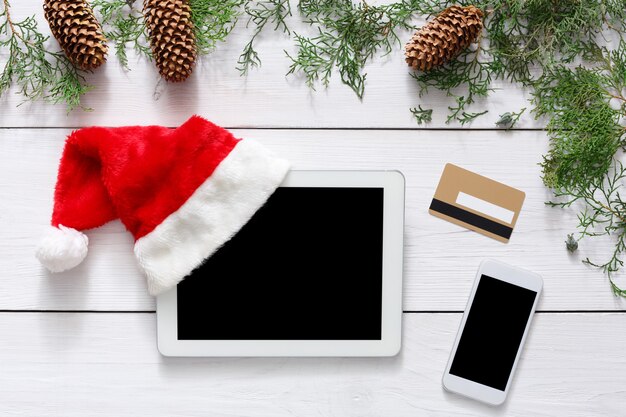 Tablet screen on white wooden table with Christmas decorations