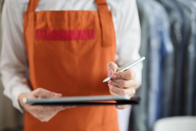 Tablet with stylus in female hands in uniform closeup