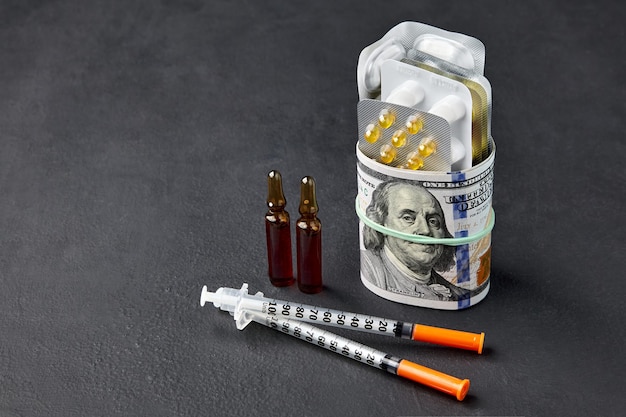 Tablets and ampoules are wrapped in hundred dollar bills fastened with a rubber band and insulin