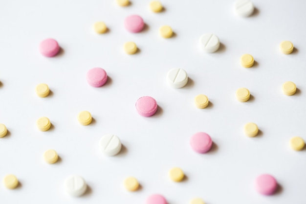 Tablets Yellow and pink pills on white background top view