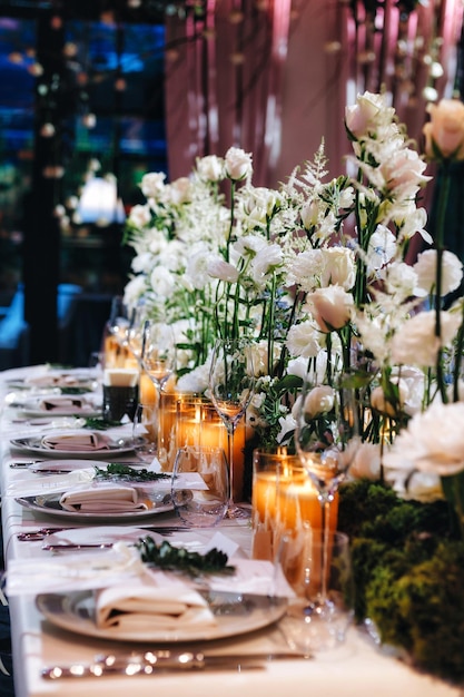 Tableware glasses flower fork knife served for dinner in restaurant with cozy interior