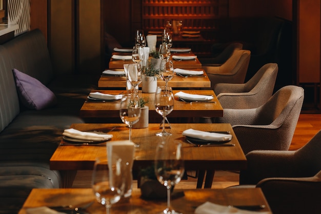 Tableware Glasses, flower fork, knife served for dinner in restaurant with cozy interior