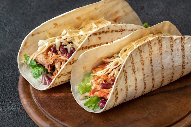 Tacos - traditional Mexican dish on wooden board