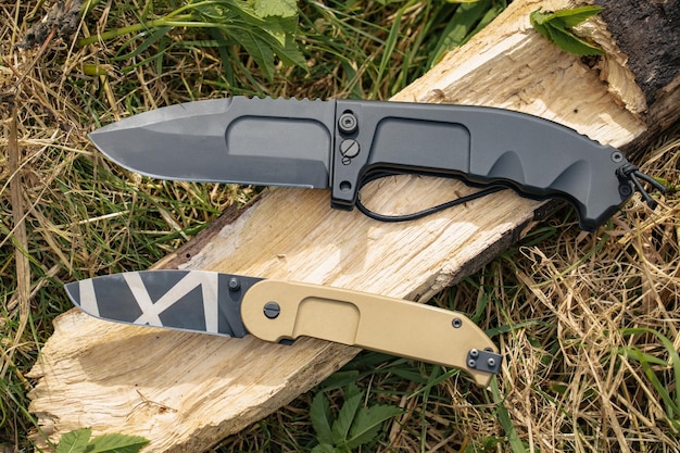 Tactical folding knives in nature closeup photo High quality photo