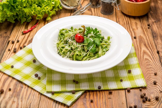 Tagliatelle pasta with spinach and green peas pesto, selective focus