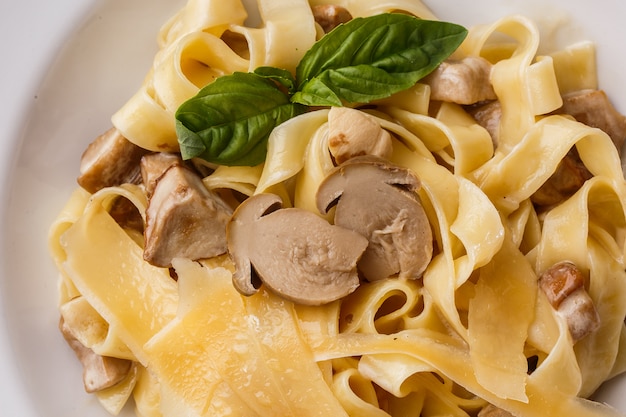 Tagliatelle vegetarian Pasta Dish with Mushrooms decorated with basil.