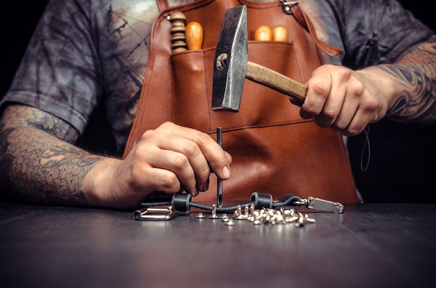 Tailor workplace with pieces of leather and rivets.