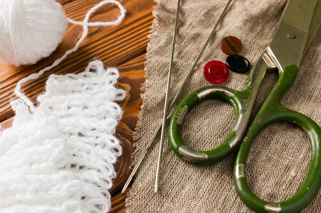 Tailors scissors on fabric next to a ball  yarn