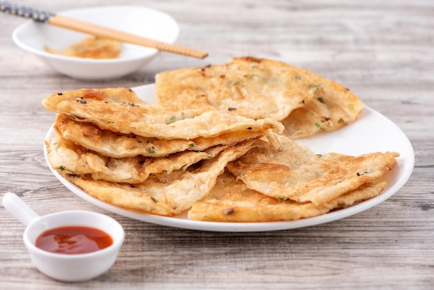 Taiwanese food delicious flaky scallion pie pancakes on bright wooden table background traditional snack in Taiwan close up