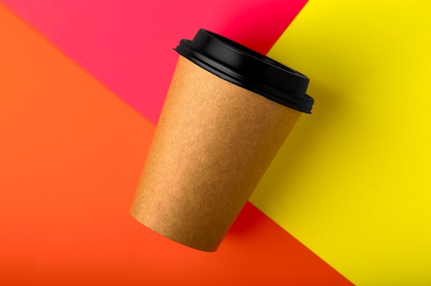 Take away coffee cup on red orange yellow colorful paper background