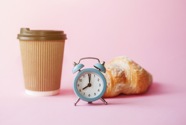 Take away coffee in paper cup, retro alarm clock