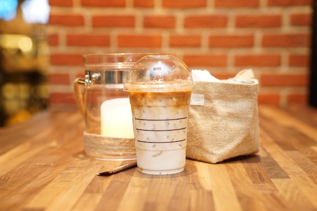 Take away Latte with Brick on the wood table