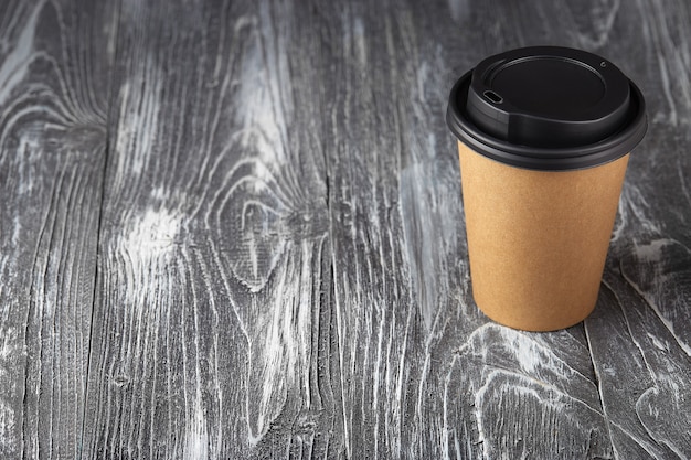 Take away paper coffee cup on grey wooden background