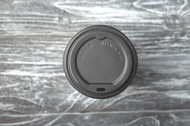 Take away plastic coffee cup cap on grey wooden background