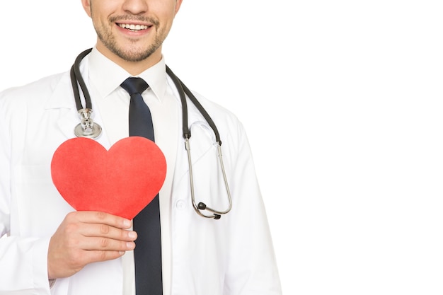 Take care of your heart. Cropped studio shot of a male doctor holding red heart and smiling cheerfully isolated on white