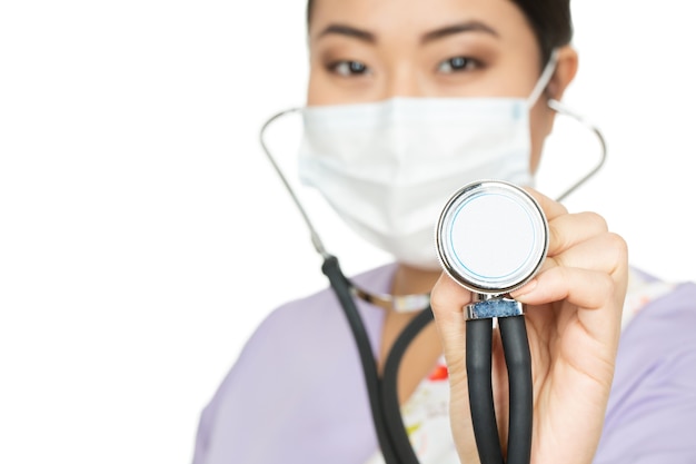 Take a listen. Cropped closeup of a female doctor wearing surgical mask holding stethoscope