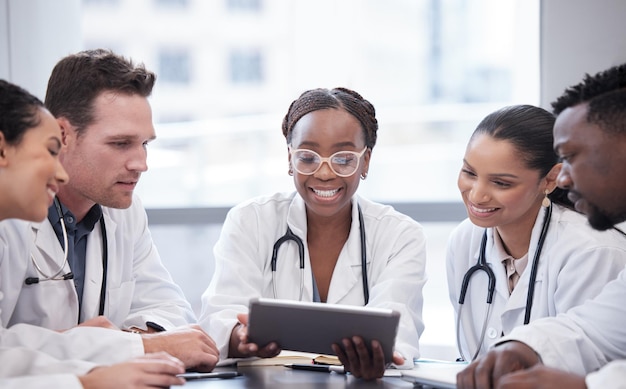 Take a look at this Cropped shot of a group of young doctors looking at a tablet during a meeting in the hospital boardroom