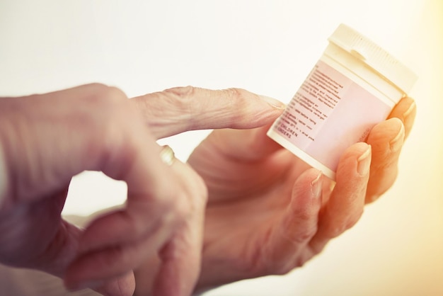 Take one tablet twice daily Cropped shot of an elderly woman checking the container of medicine shes holding