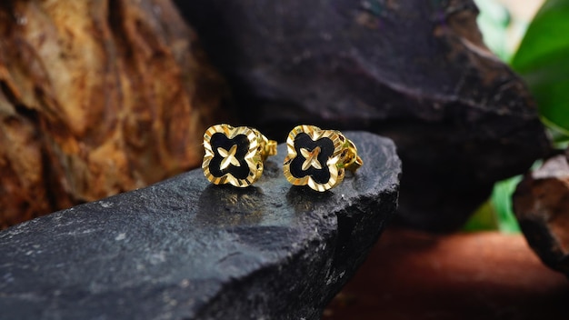 Take a photo of a pair of gold earrings on a rock background