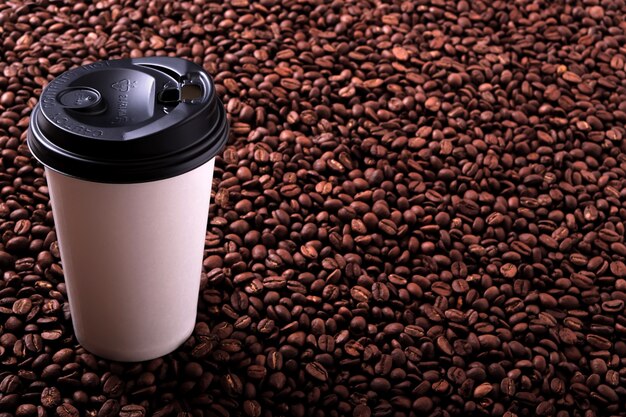 Takeaway coffee cup with roasted beans background