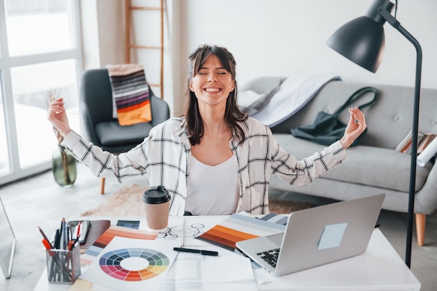 Takes a break Young female freelance worker is indoors in home at daytime