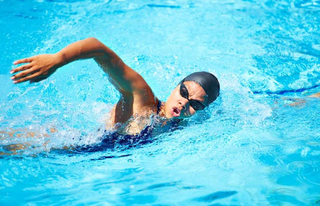 Taking a deep breath Female swimmer doing freestroke in a pool