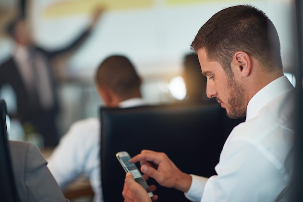 Taking notes on his smartphone Cropped shot of a young businessman using his cellphone while sitting in the boardroom