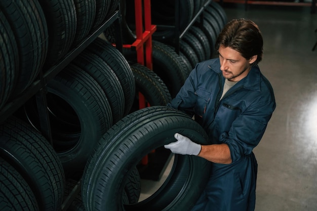 Taking one tire to for changing Man is in the tire fitting car service