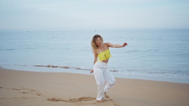 Talented woman performing modern dance on sandy beach girl dancer freestyle